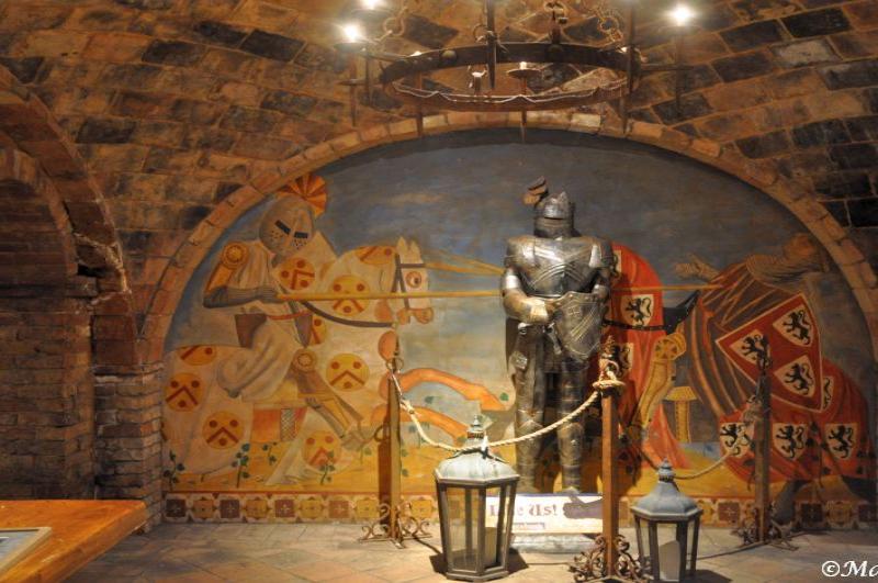 Castello Di Amorosa: доспехи рыцаря и фреска с гербами в подземном зале
